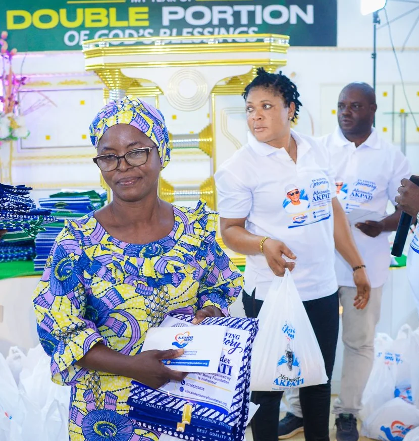 A woman smiles as the Foundation team hands her a gift at the widows’ outreach in Akute.