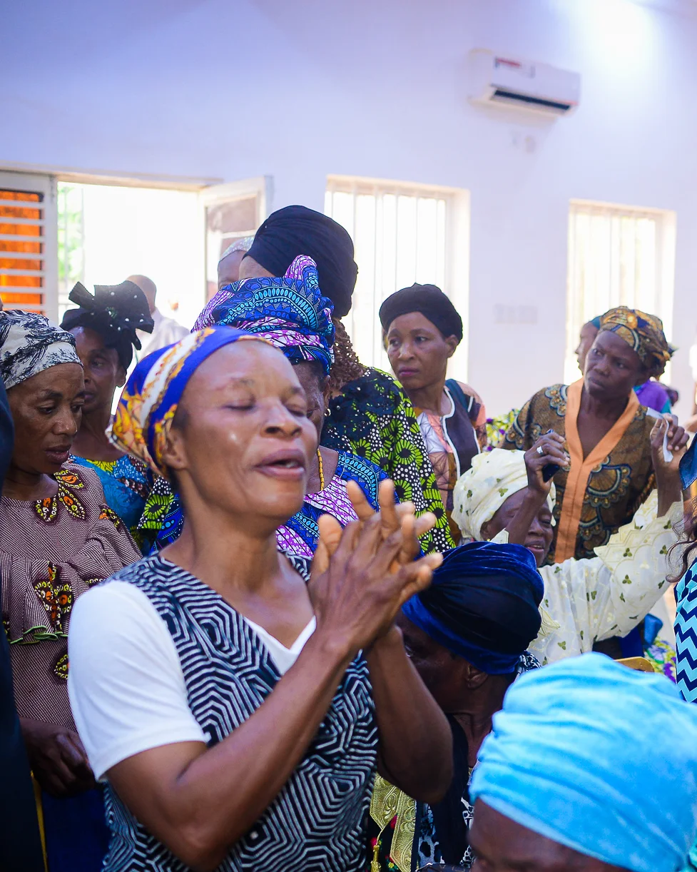 A woman lifts her hands in praise at the Foundation’s widows’ outreach in Akute.