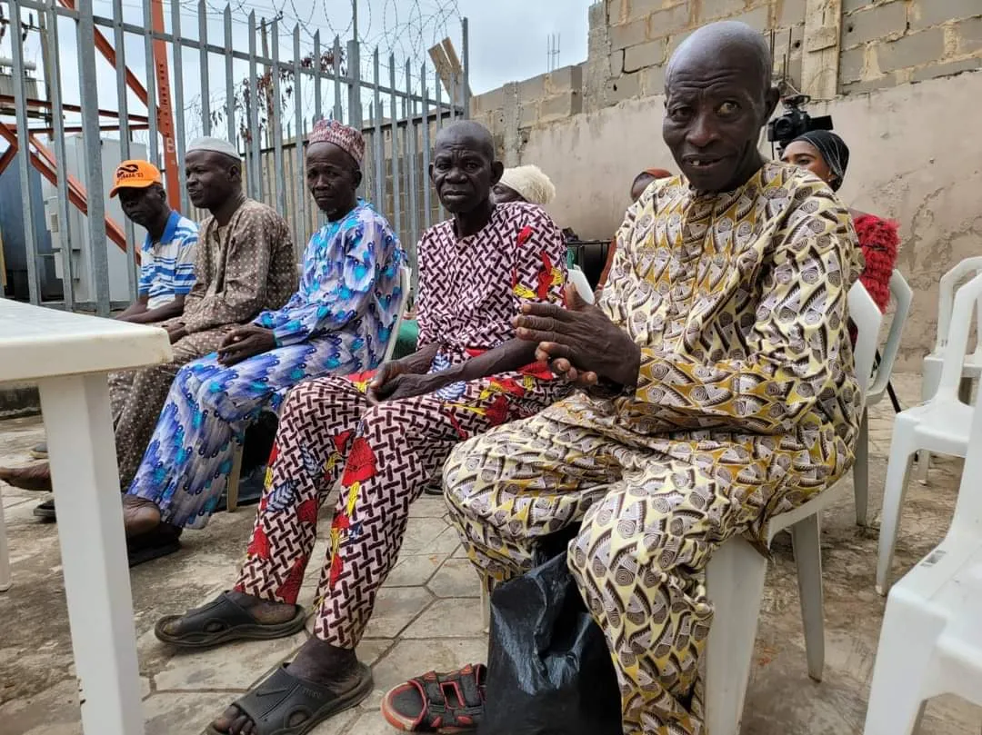 Older men and women seated outdoors at a Foundation outreach.
