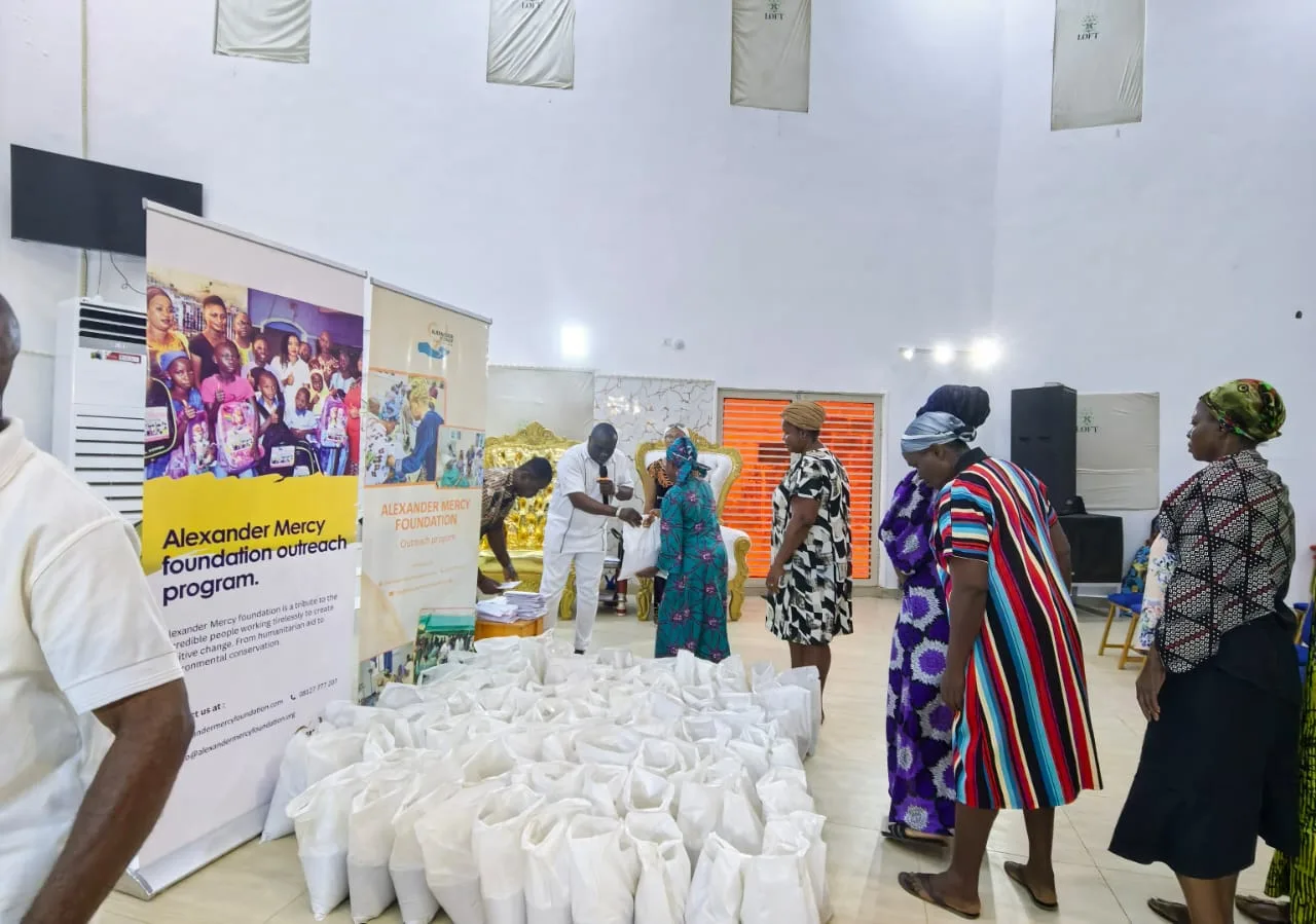Women queuing as a volunteer hands out bags of food at a Foundation outreach.