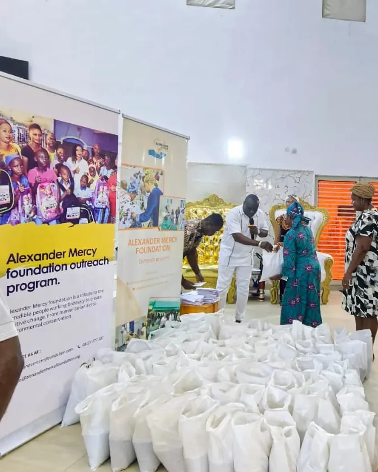 Women collect bags of food beside the Foundation’s banners at an outreach programme in Lagos.